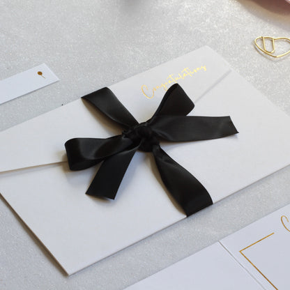Black ribbon on white greeting card with money pocket