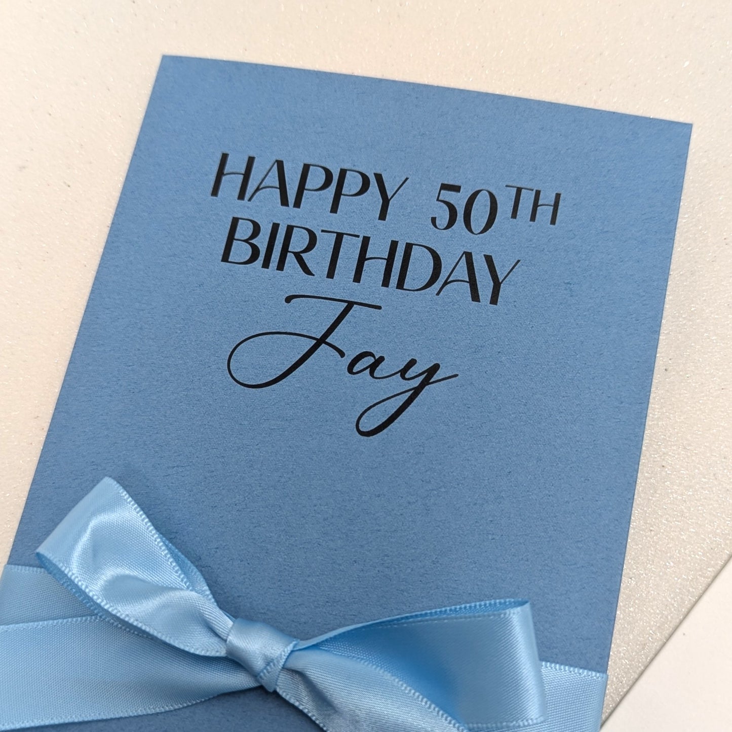 Close up of Personalised Blue 50th Birthday Money Envelope with blue satin ribbon