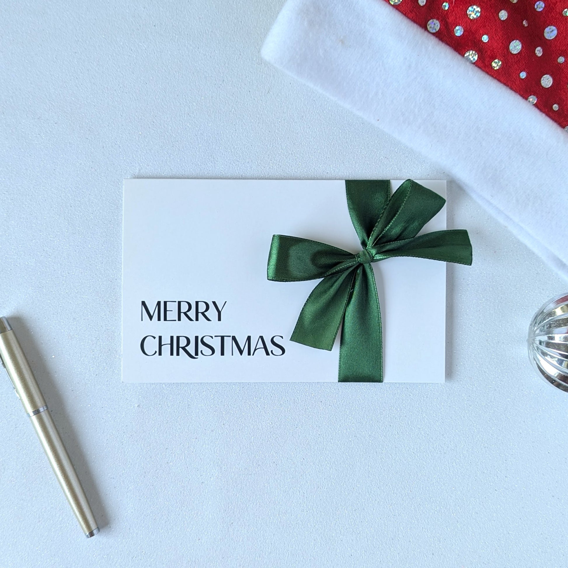 Christmas money wallet envelope for cash gift with money in the gift pocket. Green satin ribbon and black vinyl Merry Christmas