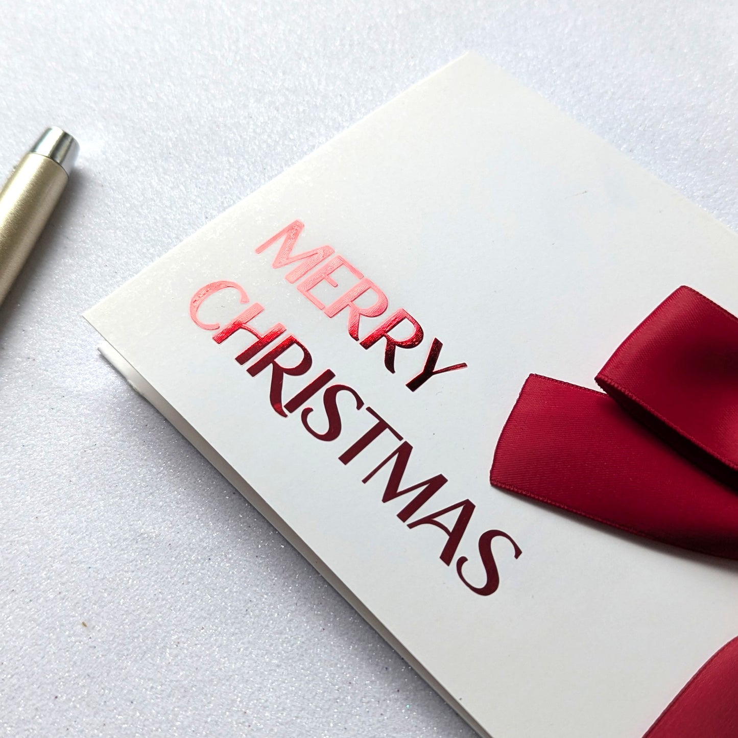 Close up of Christmas Money gift envelope with red "Merry Christmas" and Red Satin Ribbon