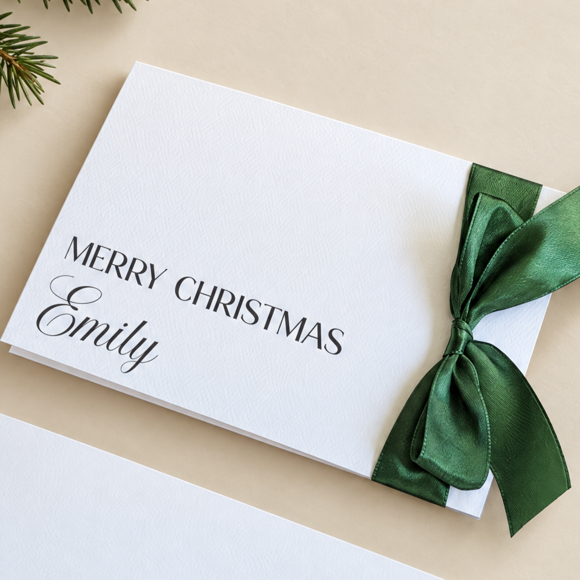 Close up of personalised christmas card with green ribbon