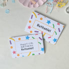 Custom illustrated birthday card envelope with matching confetti graphics and recipient's name printed on 200gsm premium heavyweight cardstock.