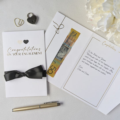 Congratulations on your engagement gift envelope with black and white glitter hearts and black satin ribbon with gift in the gift envelope. Luxury Engagement Card