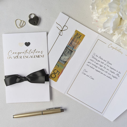 Congratulations on your engagement gift envelope with black and white glitter hearts and black satin ribbon with gift in the gift envelope. Luxury Engagement Card