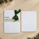 christmas card with merry christmas printed in black ink and a green satin ribbon.  this card has a pocket for the gift card or voucher