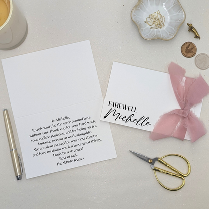 Luxury personalised farewell card with 'Farewell [Name]' printed on heavy-weight paper. Featuring a pink chiffon frayed-edge ribbon and a professional printed message inside in modern sans serif font.