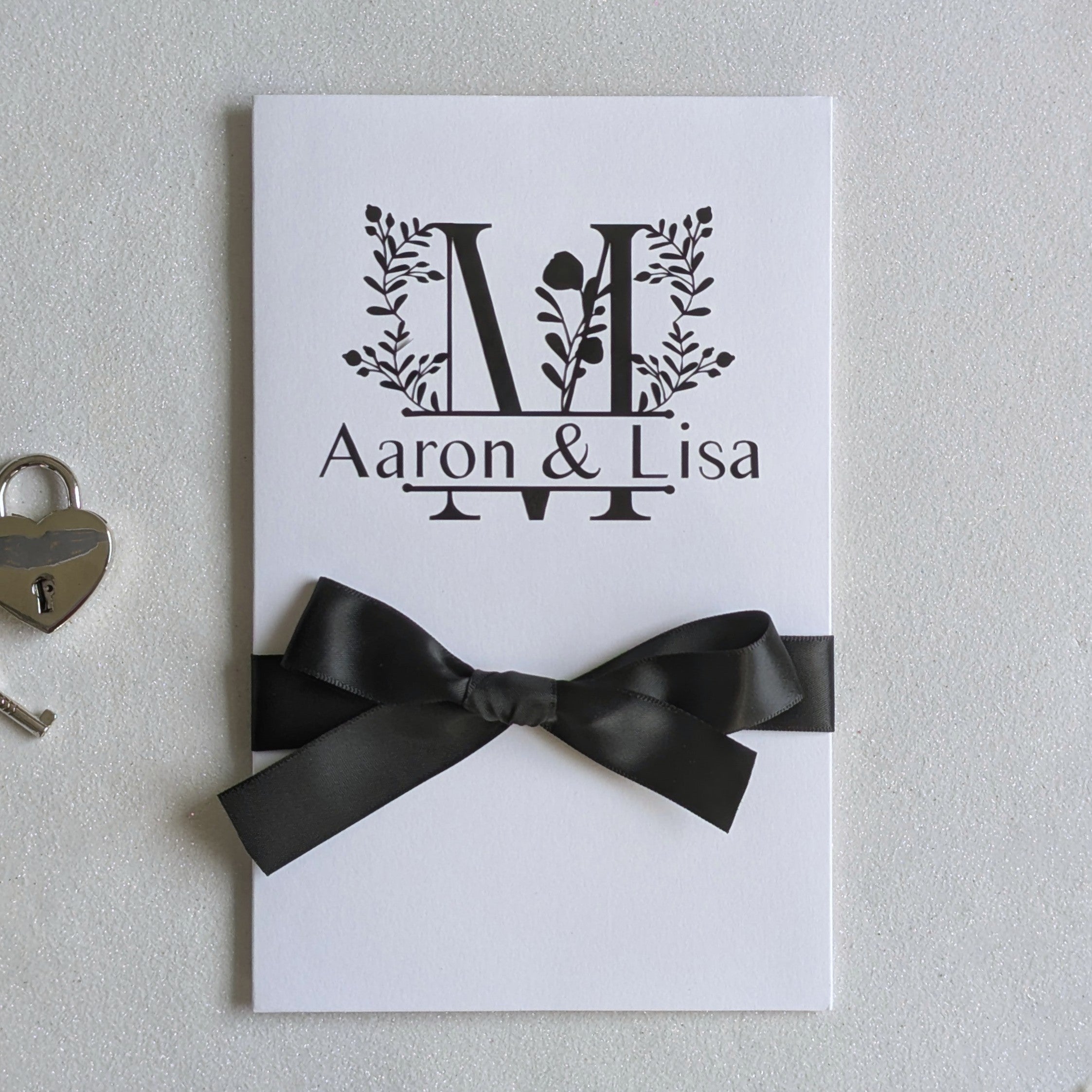 Monogram Personalised White wedding card with money pocket close up with Black vinyl monogram of Aaron and Lisa with a large floral M