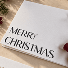 Close up of textured card with Merry Christmas printed in black ink