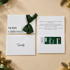 christmas card with merry christmas printed in black ink and a green satin ribbon. Custom message printed inside the card and recipients name printed on the envelope. this card has a pocket for the gift card or voucher