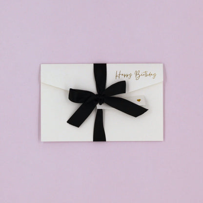 White happy birthday greeting card with black ribbon and white name tag